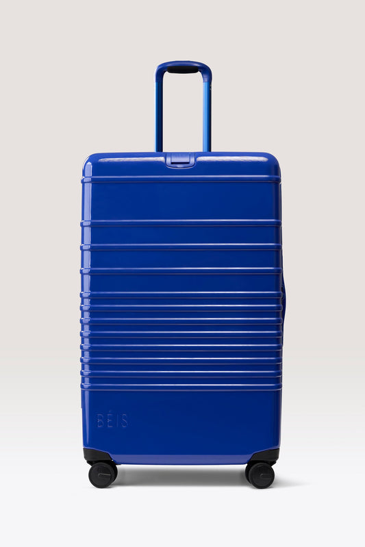 La maleta grande de facturación con ruedas en azul cobalto brillante